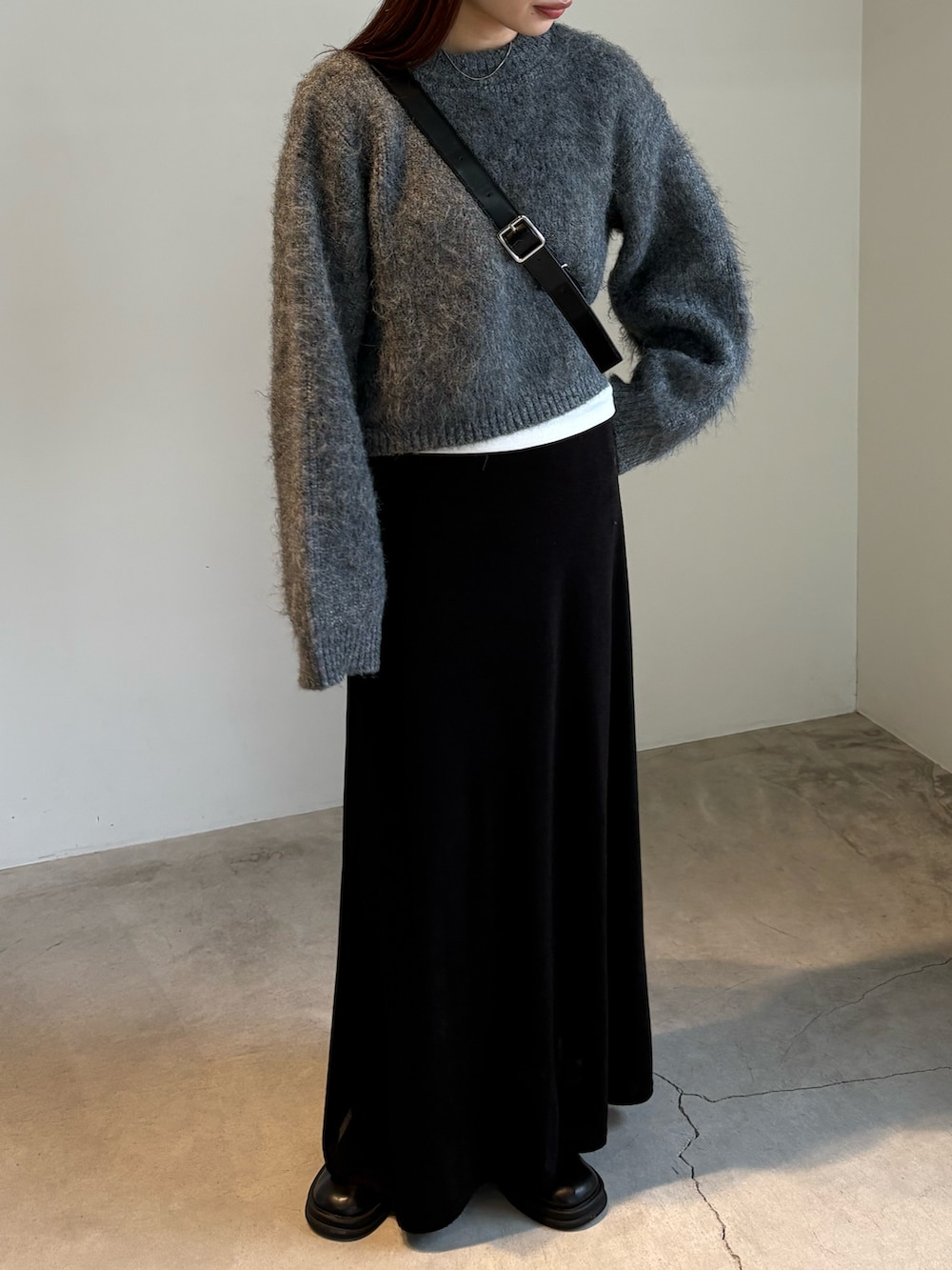 ブラック系のスカート、ブラック系のスリッポン、グレー系のニット/セーターを着用したレディースの秋コーディネートの3枚目の写真