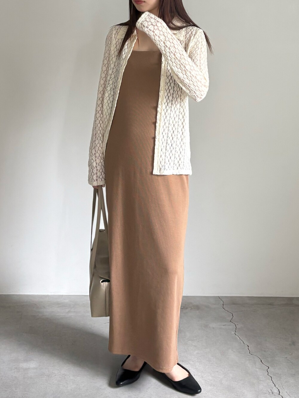 イエロー系のワンピース、ホワイト系のシャツ/ブラウス、ベージュ系のショルダーバッグを着用したレディースの春コーディネートの2枚目の写真