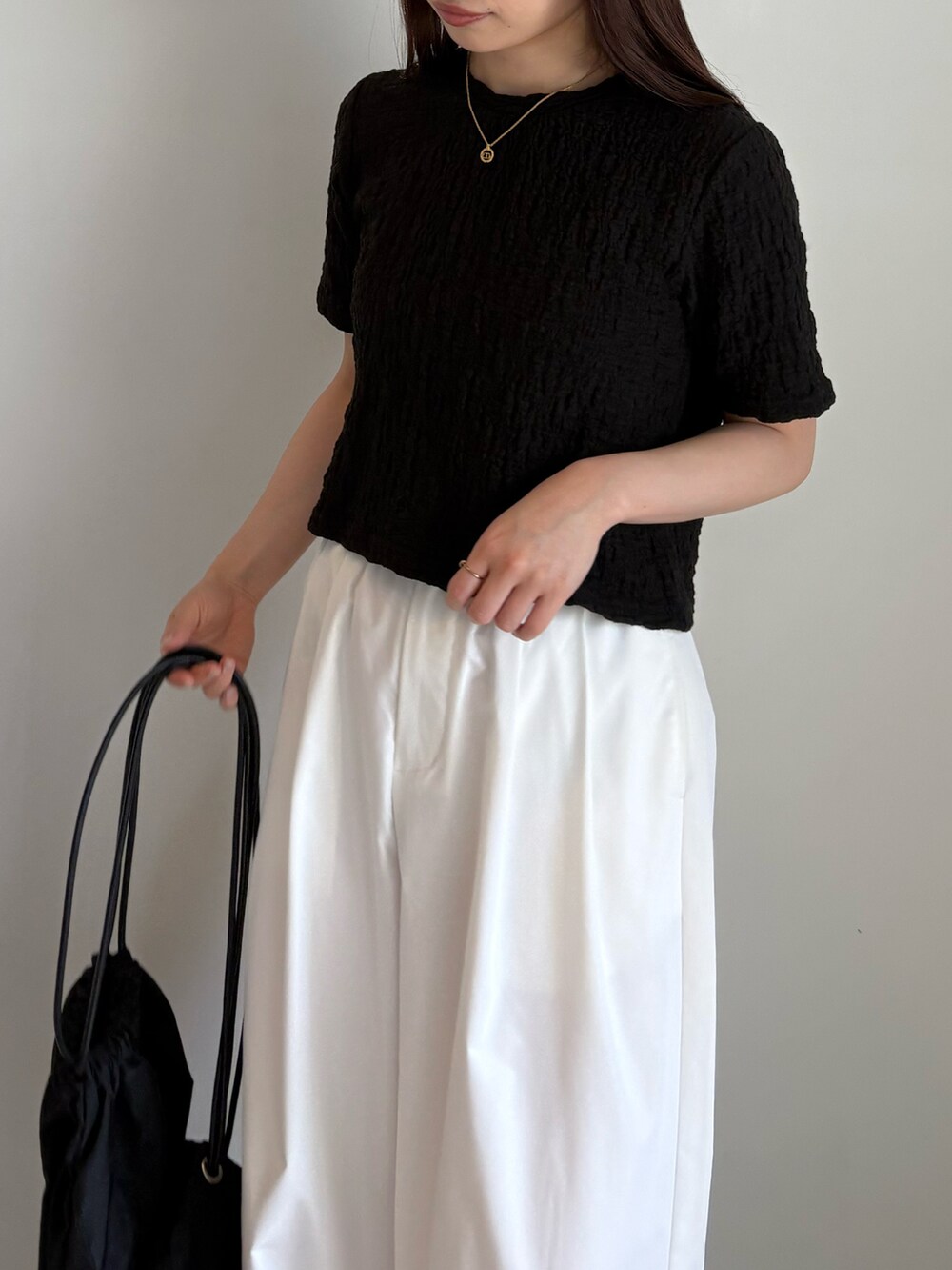 ブラック系のTシャツ/カットソー、ホワイト系のその他パンツ、ブラック系のバックパック/リュックを着用したレディースの夏コーディネートの3枚目の写真