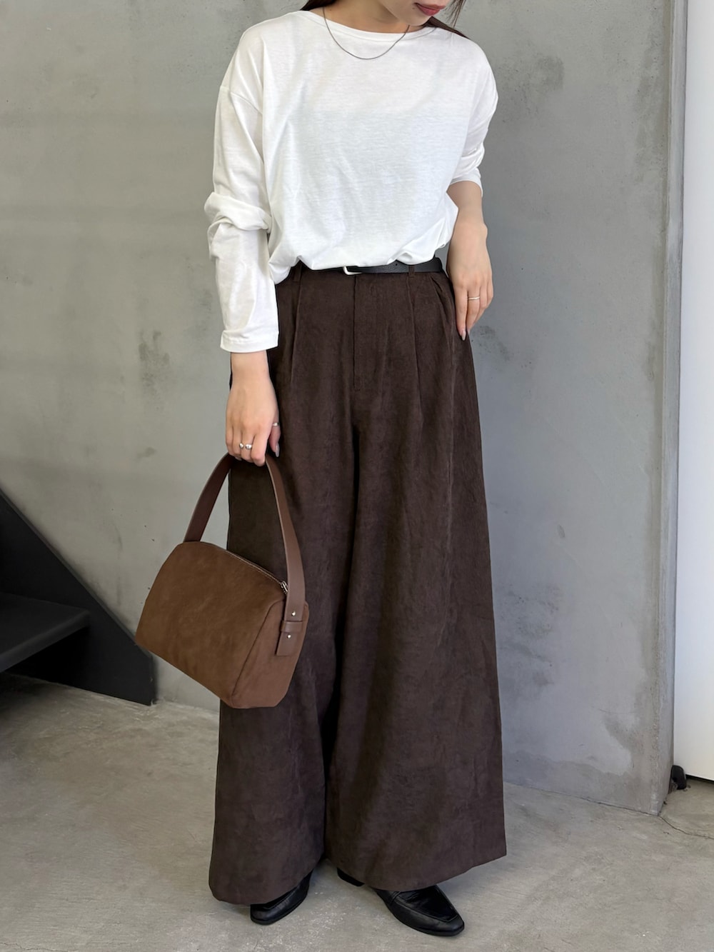 ホワイト系のTシャツ/カットソー、ブラウン系のスラックス、ブラウン系のハンドバッグを着用したレディースの夏コーディネートの3枚目の写真