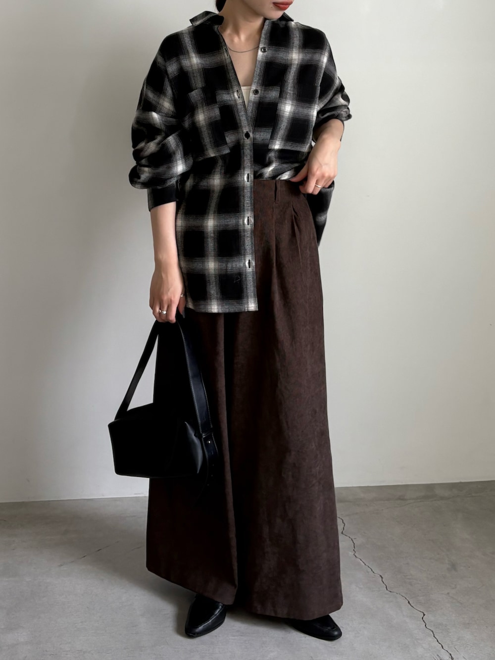 ブラック系のシャツ/ブラウス、ブラウン系のスラックス、ホワイト系のキャミソールを着用したレディースの夏コーディネートの2枚目の写真