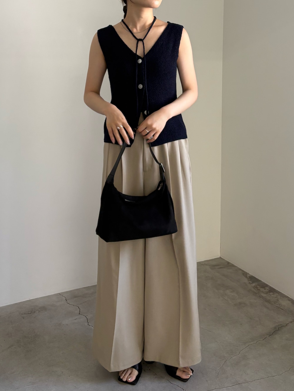 ブルー系のベスト、ベージュ系のスラックス、ブラック系のサンダルを着用したレディースの夏コーディネートの4枚目の写真
