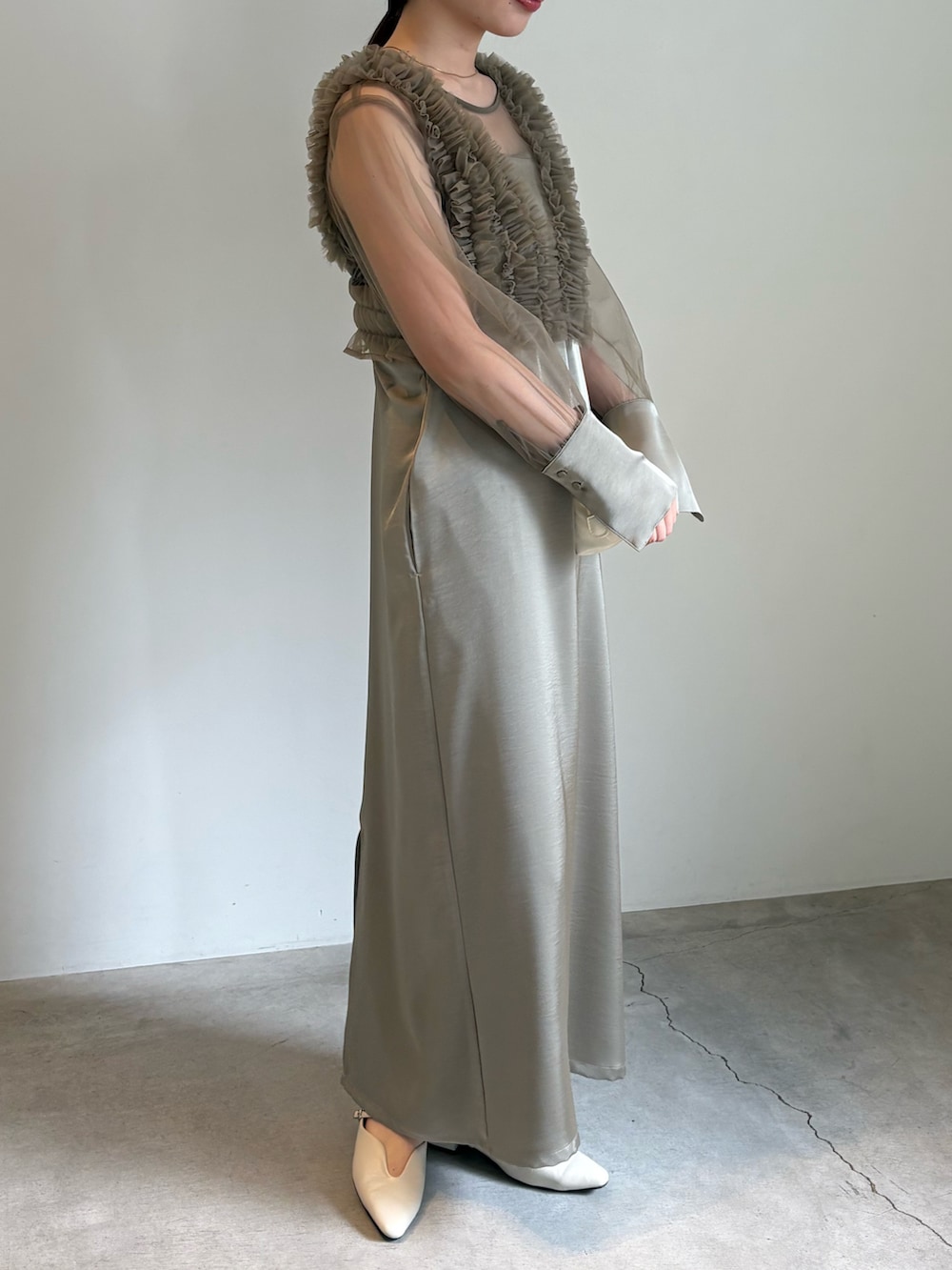 ブラック系のキャミソール、ホワイト系のショルダーバッグ、ベージュ系のドレスを着用したレディースの春コーディネートの3枚目の写真