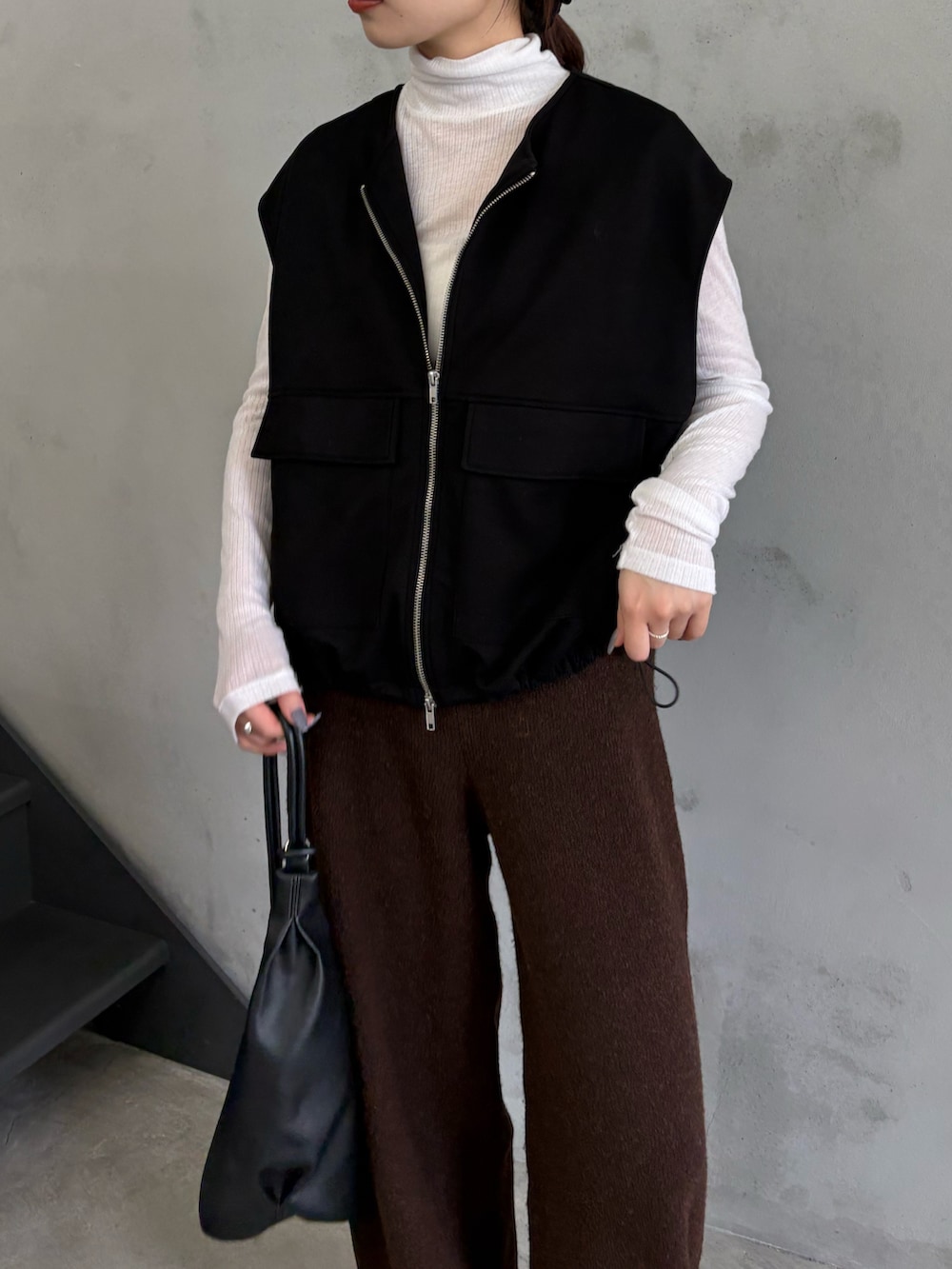 ブラック系のベスト、ホワイト系のTシャツ/カットソー、ブラウン系のその他パンツを着用したレディースの秋コーディネートの4枚目の写真