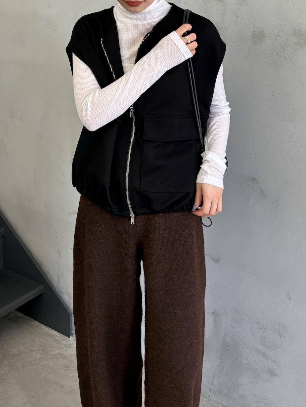 ブラック系のベスト、ホワイト系のTシャツ/カットソー、ブラウン系のその他パンツを着用したレディースの秋コーディネートの5枚目の写真