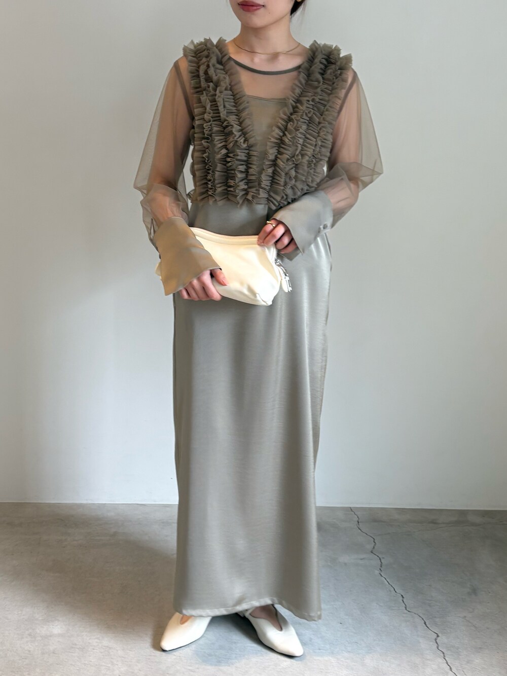 ブラック系のキャミソール、ホワイト系のショルダーバッグ、ベージュ系のドレスを着用したレディースの春コーディネートの2枚目の写真