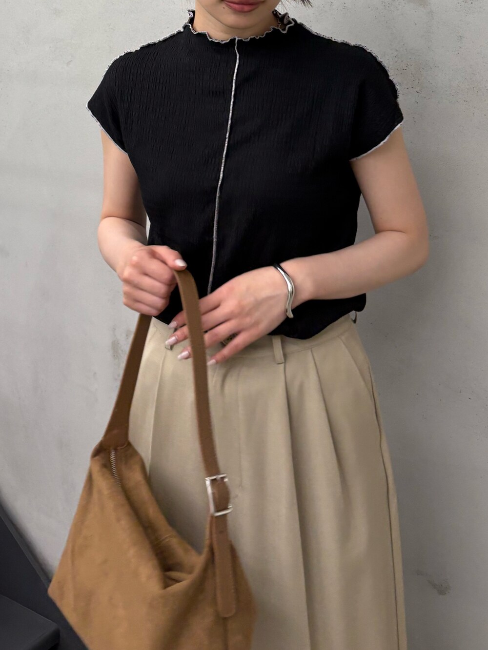 ブラック系のTシャツ/カットソー、ベージュ系のスラックス、ブラック系のサンダルを着用したレディースの夏コーディネートの4枚目の写真