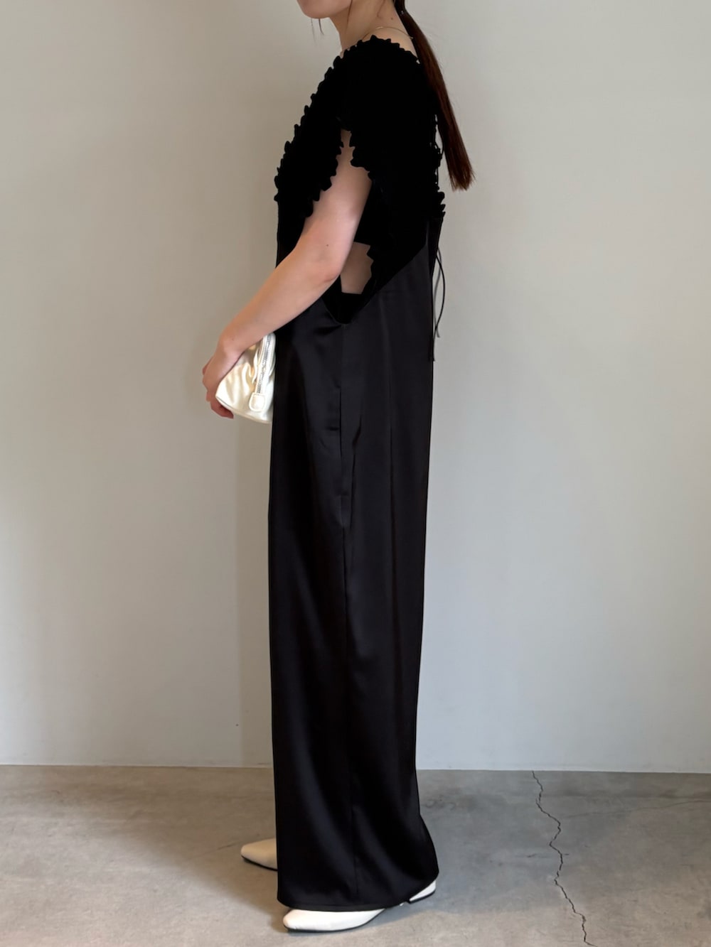 ホワイト系のショルダーバッグ、ブラック系のキャミソール、ブラック系のパンツドレスを着用したレディースの春コーディネートの4枚目の写真