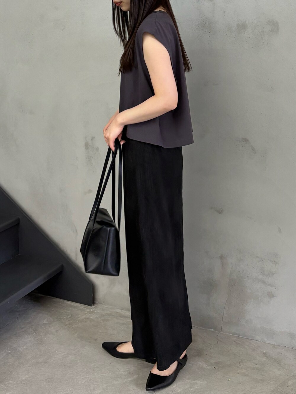 ブラック系のTシャツ/カットソー、ブラック系のスカート、ブラック系のショルダーバッグを着用したレディースの春コーディネートの4枚目の写真