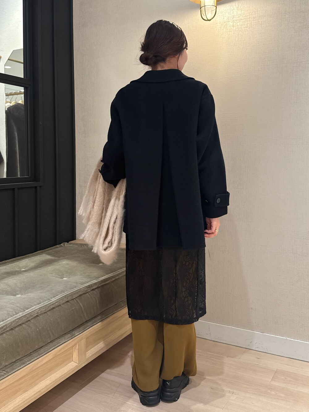 ブラック系のスカート、ホワイト系のカーディガン/ボレロ、ブラック系のピーコートを着用したレディースの冬コーディネートの4枚目の写真