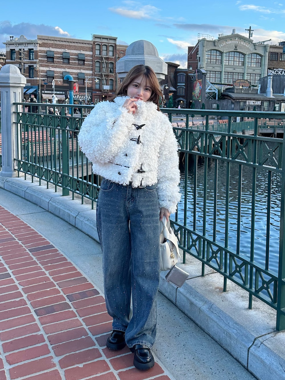 ブルー系のデニムパンツ、ブラック系のローファー、ホワイト系のその他アウターを着用したレディースの冬コーディネートの2枚目の写真