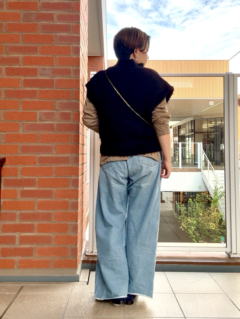 ブラック系のカーディガン/ボレロ、ブラウン系のTシャツ/カットソーを着用したレディースの秋コーディネートの4枚目の写真