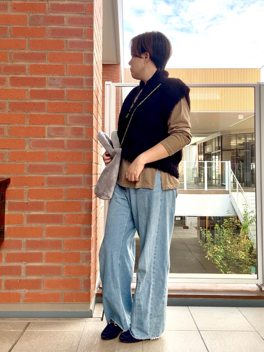 ブラック系のカーディガン/ボレロ、ブラウン系のTシャツ/カットソーを着用したレディースの秋コーディネートの3枚目の写真