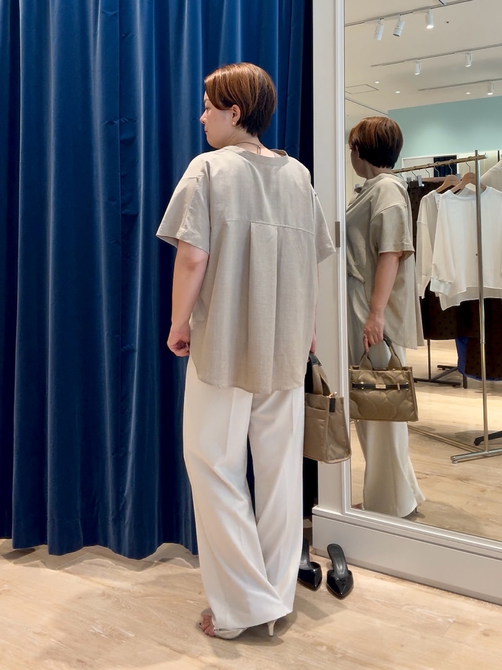 ベージュ系のシャツ/ブラウス、ホワイト系のその他パンツ、ベージュ系のトートバッグを着用したレディースの秋コーディネートの3枚目の写真