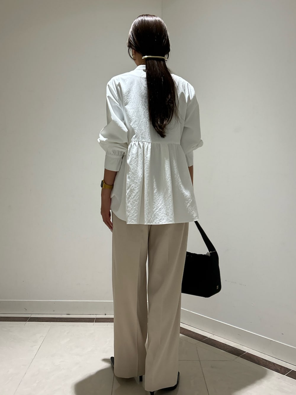 ホワイト系のシャツ/ブラウス、ホワイト系のその他パンツ、ブラック系のハンドバッグを着用したレディースの冬コーディネートの3枚目の写真