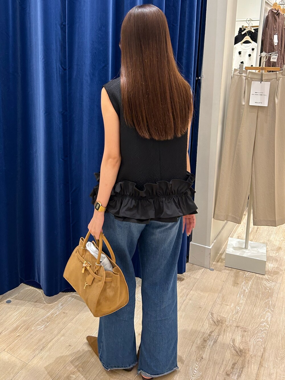 ブラック系のベスト、ブルー系のデニムパンツ、イエロー系のトートバッグを着用したレディースの夏コーディネートの3枚目の写真