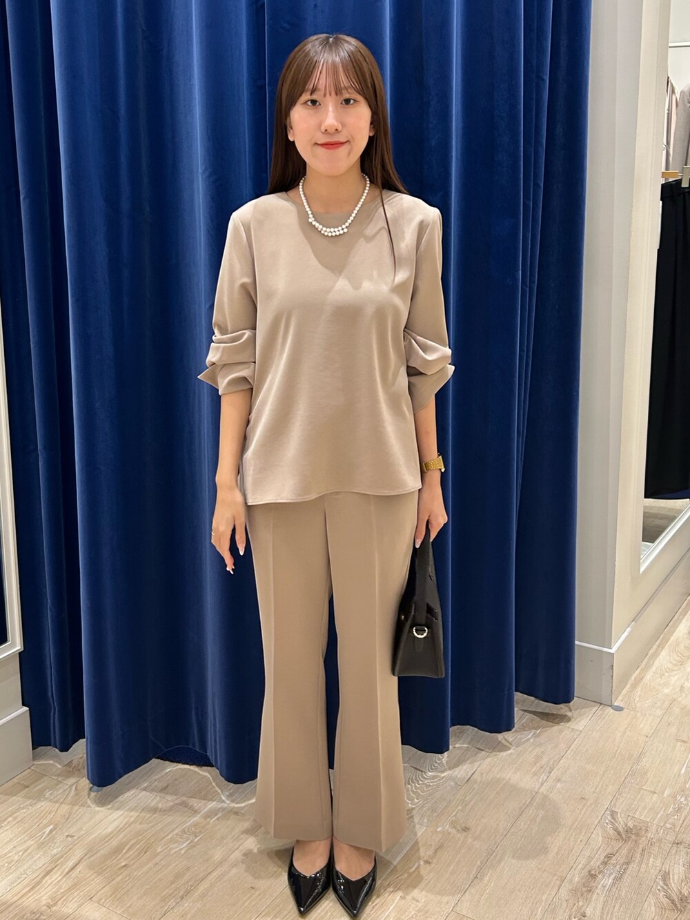 ベージュ系のその他パンツ、ベージュ系のシャツ/ブラウス、ブラック系のショルダーバッグを着用したレディースの秋コーディネートの2枚目の写真
