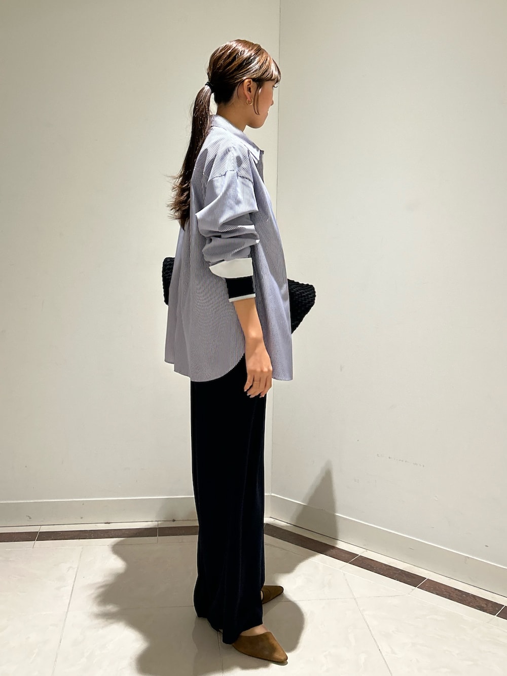 ブルー系のシャツ/ブラウス、ブルー系のTシャツ/カットソー、ブラック系のトートバッグを着用したレディースの冬コーディネートの4枚目の写真