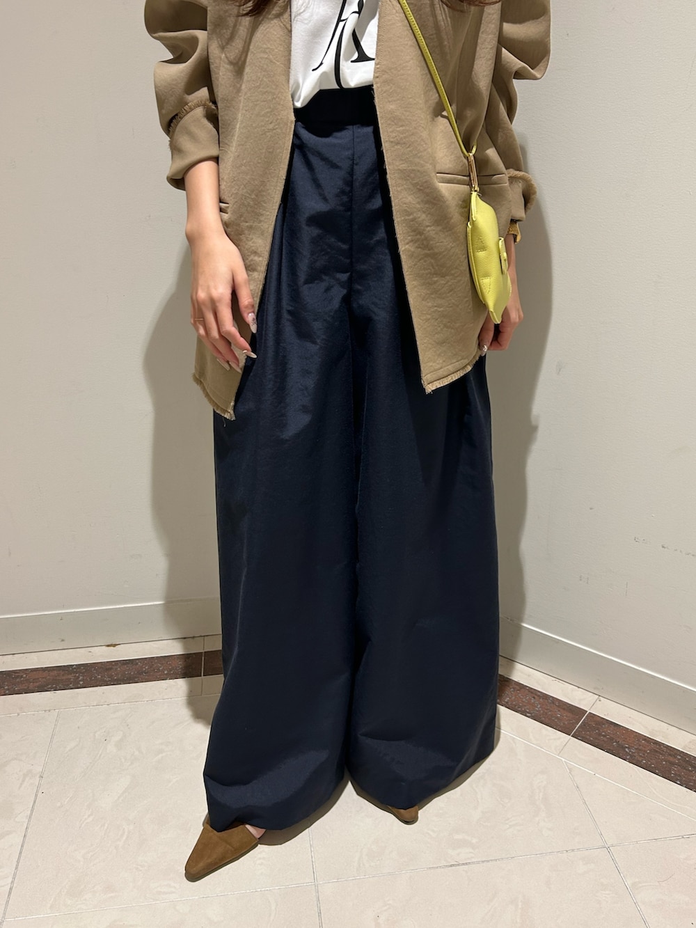 ブルー系のその他パンツ、ベージュ系のノーカラージャケット、ホワイト系のTシャツ/カットソーを着用したレディースの春コーディネートの6枚目の写真