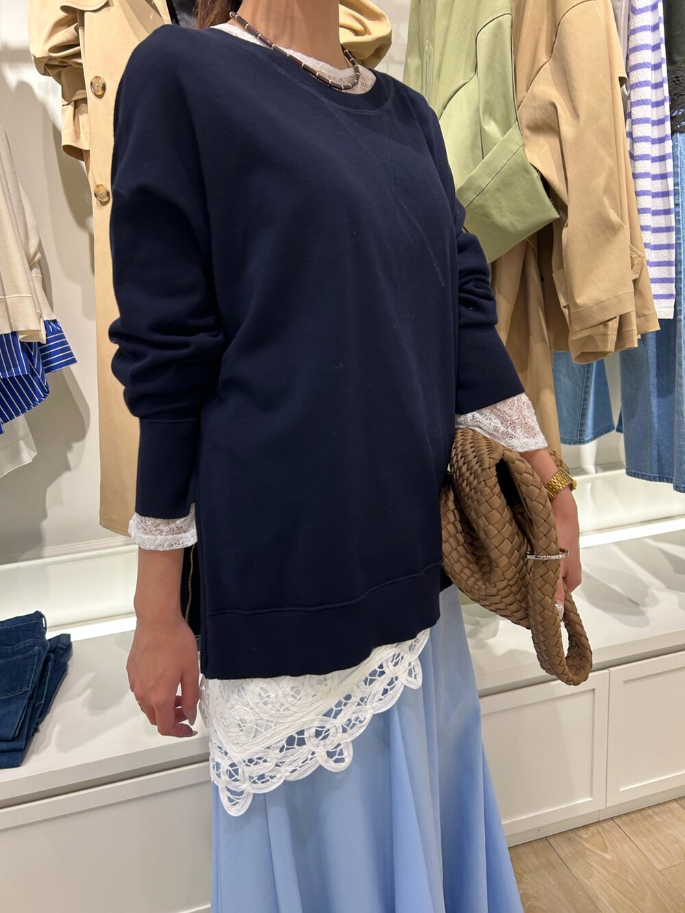 ブルー系のスカート、ブラウン系のショルダーバッグ、ブルー系のニット/セーターを着用したレディースの春コーディネートの4枚目の写真