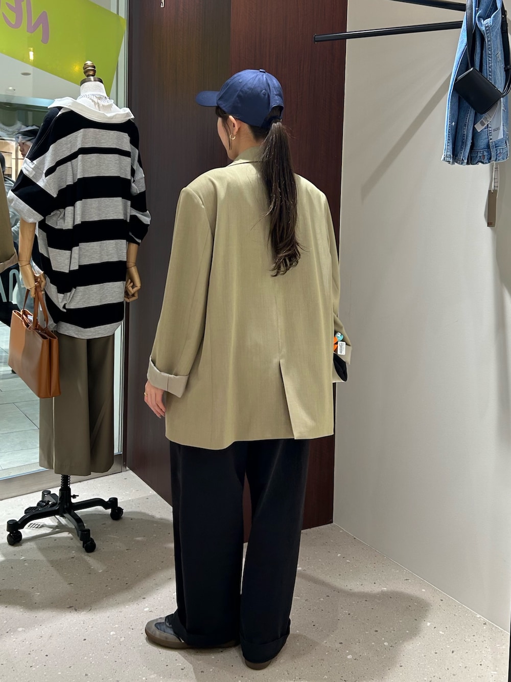 ベージュ系のテーラードジャケット、ブラック系のボディバッグ/ウエストポーチ、ホワイト系のタンクトップを着用したレディースの春コーディネートの5枚目の写真