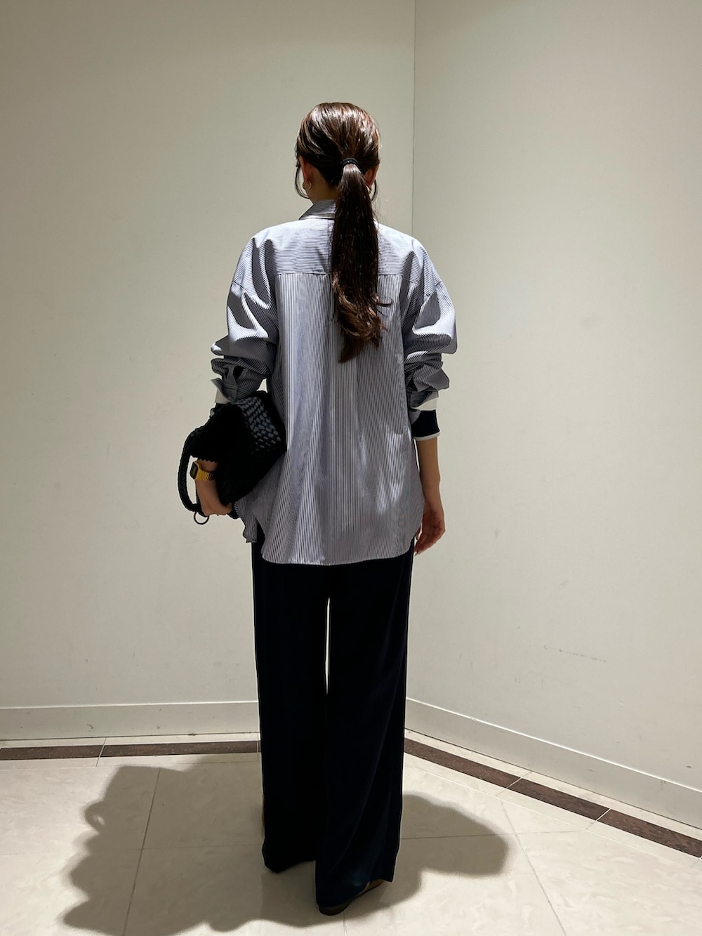 ブルー系のシャツ/ブラウス、ブルー系のTシャツ/カットソー、ブラック系のトートバッグを着用したレディースの冬コーディネートの3枚目の写真