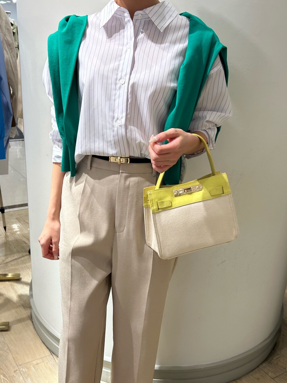 イエロー系のショルダーバッグ、ベージュ系のその他パンツ、グリーン系のカーディガン/ボレロを着用したレディースの春コーディネートの7枚目の写真