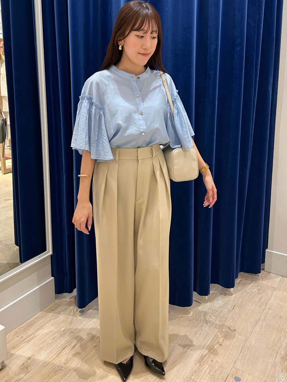 ブルー系のシャツ/ブラウス、ベージュ系のその他パンツ、ブラック系のショルダーバッグを着用したレディースの夏コーディネートの2枚目の写真