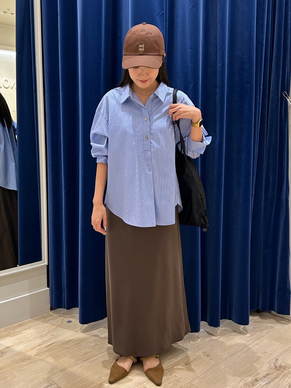 ブルー系のシャツ/ブラウス、ブラウン系のスカート、ブラック系のショルダーバッグを着用したレディースの秋コーディネートの3枚目の写真