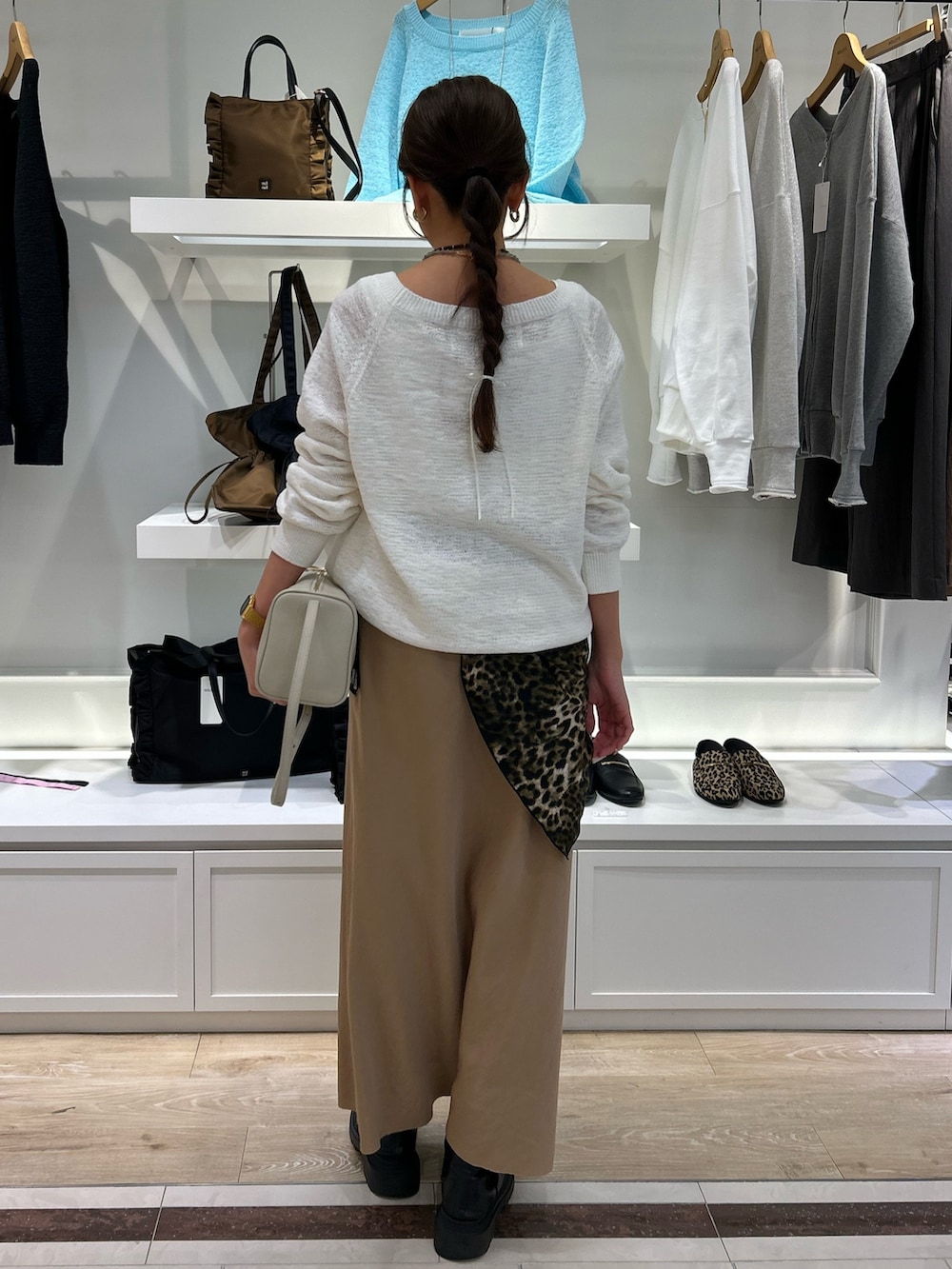 ホワイト系のニット/セーター、ホワイト系のショルダーバッグ、ベージュ系のスカートを着用したレディースの冬コーディネートの3枚目の写真
