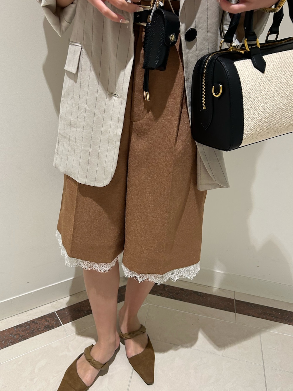 ブラック系のボストンバッグ、イエロー系のその他パンツ、ホワイト系のTシャツ/カットソーを着用したレディースの春コーディネートの5枚目の写真