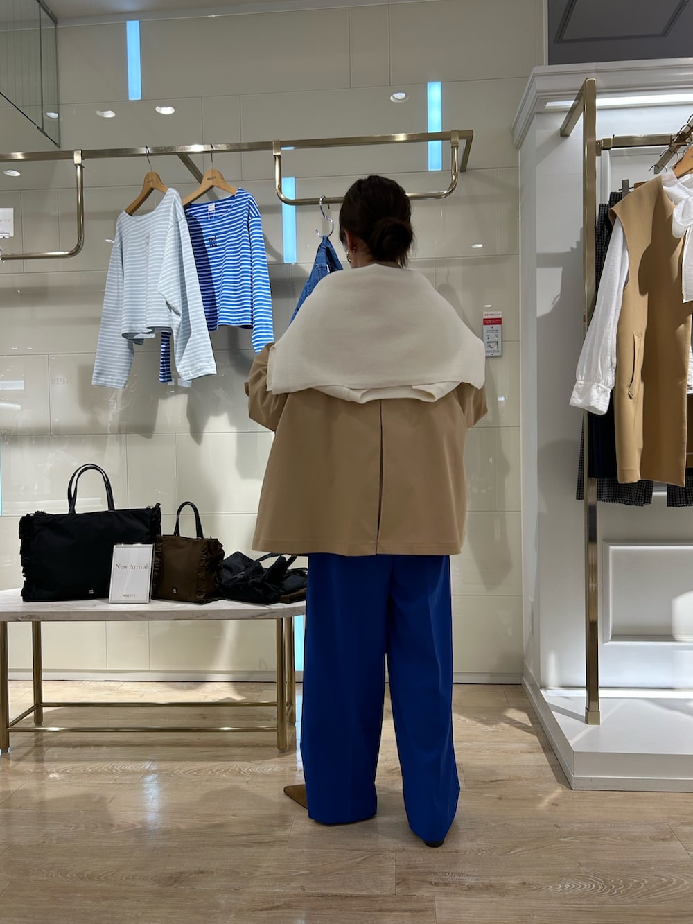 ベージュ系のブルゾン、ブラック系のショルダーバッグ、ホワイト系のTシャツ/カットソーを着用したレディースの冬コーディネートの3枚目の写真