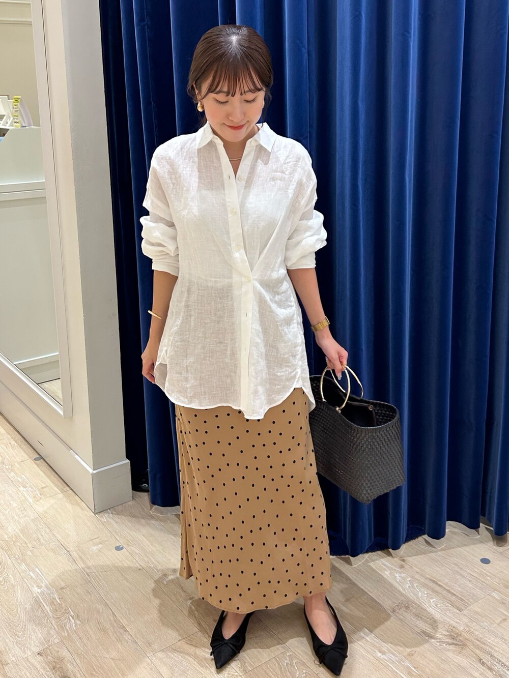 ホワイト系のシャツ/ブラウス、ブラック系のかごバッグ、ブラウン系のスカートを着用したレディースの夏コーディネートの2枚目の写真