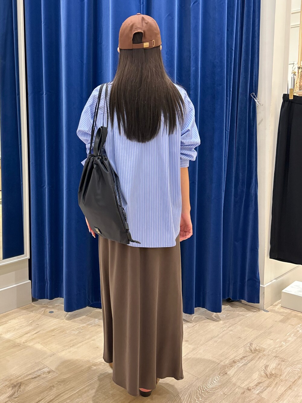ブルー系のシャツ/ブラウス、ブラウン系のスカート、ブラック系のショルダーバッグを着用したレディースの秋コーディネートの2枚目の写真