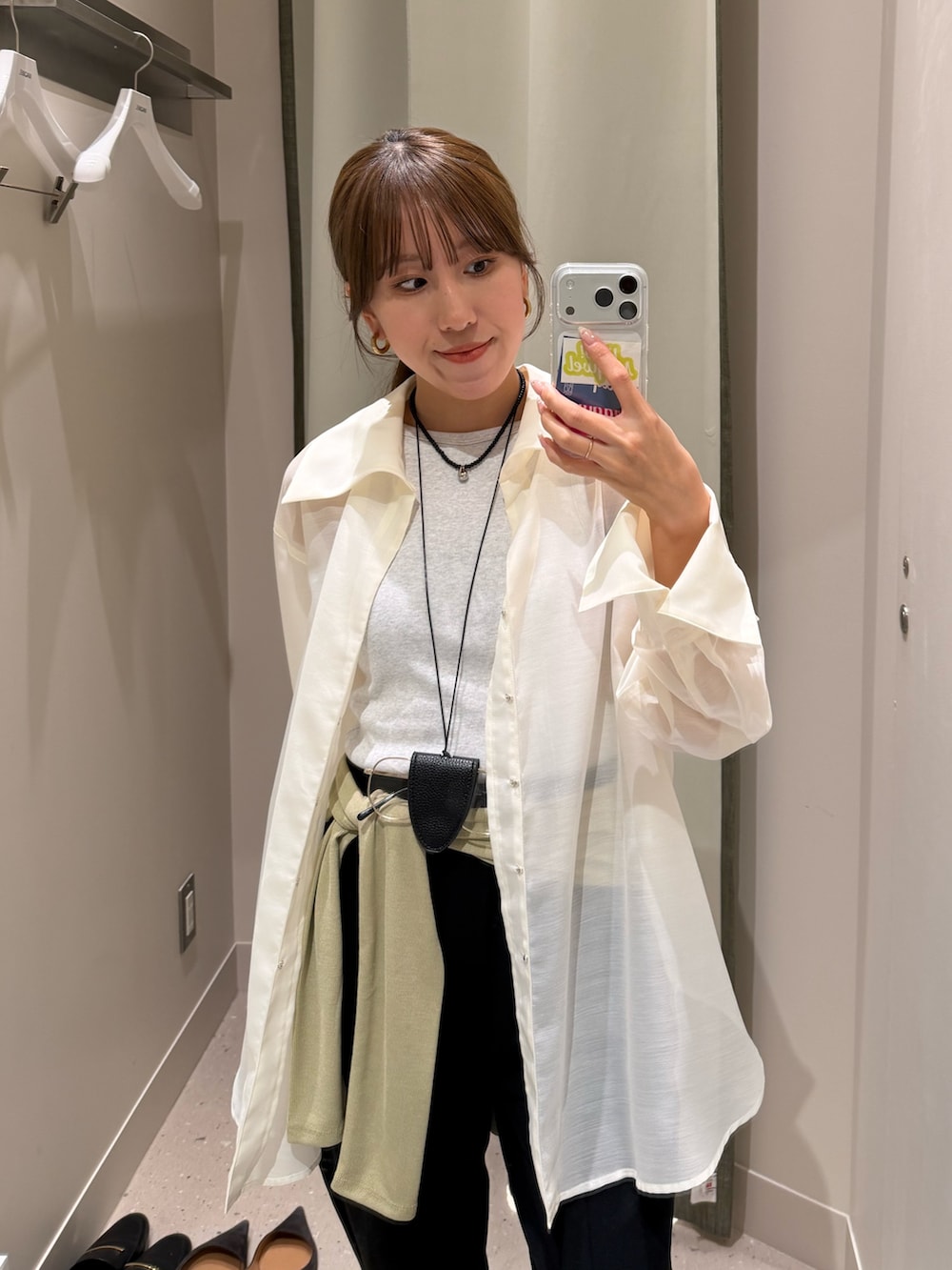 ブラック系のその他パンツ、ホワイト系のクラッチバッグ、ホワイト系のシャツ/ブラウスを着用したレディースの春コーディネートの3枚目の写真
