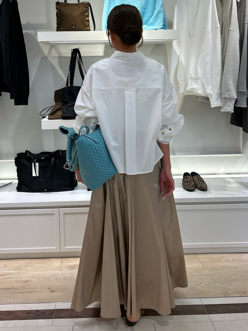 ホワイト系のシャツ/ブラウス、ゴールド系のスカート、ブルー系のトートバッグを着用したレディースの冬コーディネートの2枚目の写真