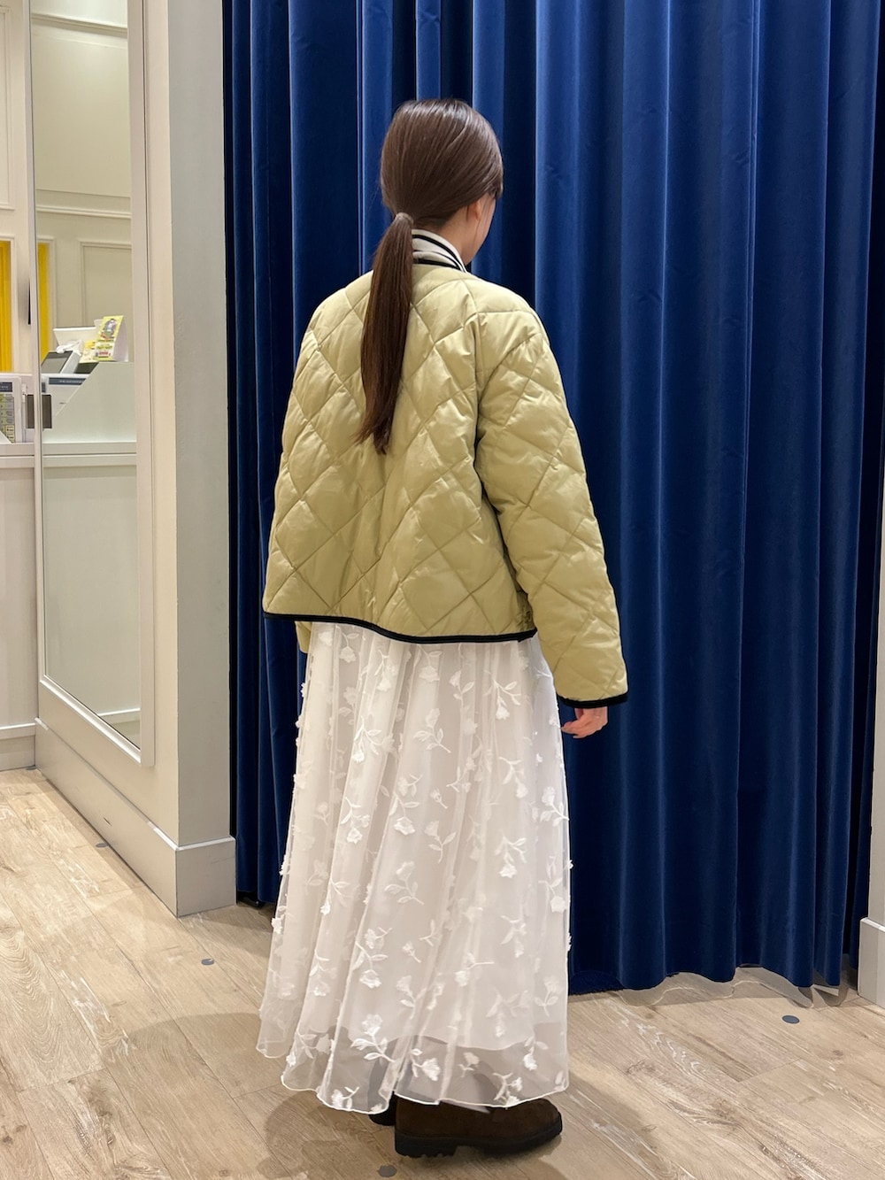 ベージュ系のダウンジャケット/コート、ホワイト系のニット/セーター、ブルー系のショルダーバッグを着用したレディースの秋コーディネートの3枚目の写真