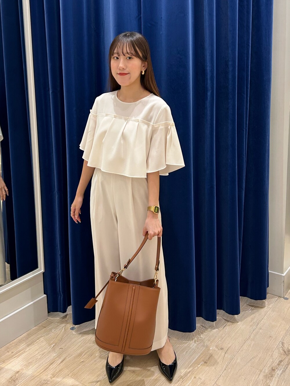 ホワイト系のシャツ/ブラウス、ホワイト系のその他パンツ、ブラウン系のショルダーバッグを着用したレディースの春コーディネートの2枚目の写真