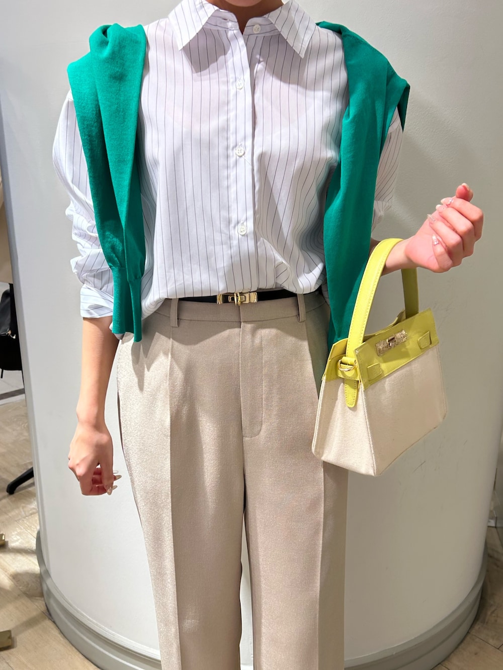 イエロー系のショルダーバッグ、ベージュ系のその他パンツ、グリーン系のカーディガン/ボレロを着用したレディースの春コーディネートの6枚目の写真