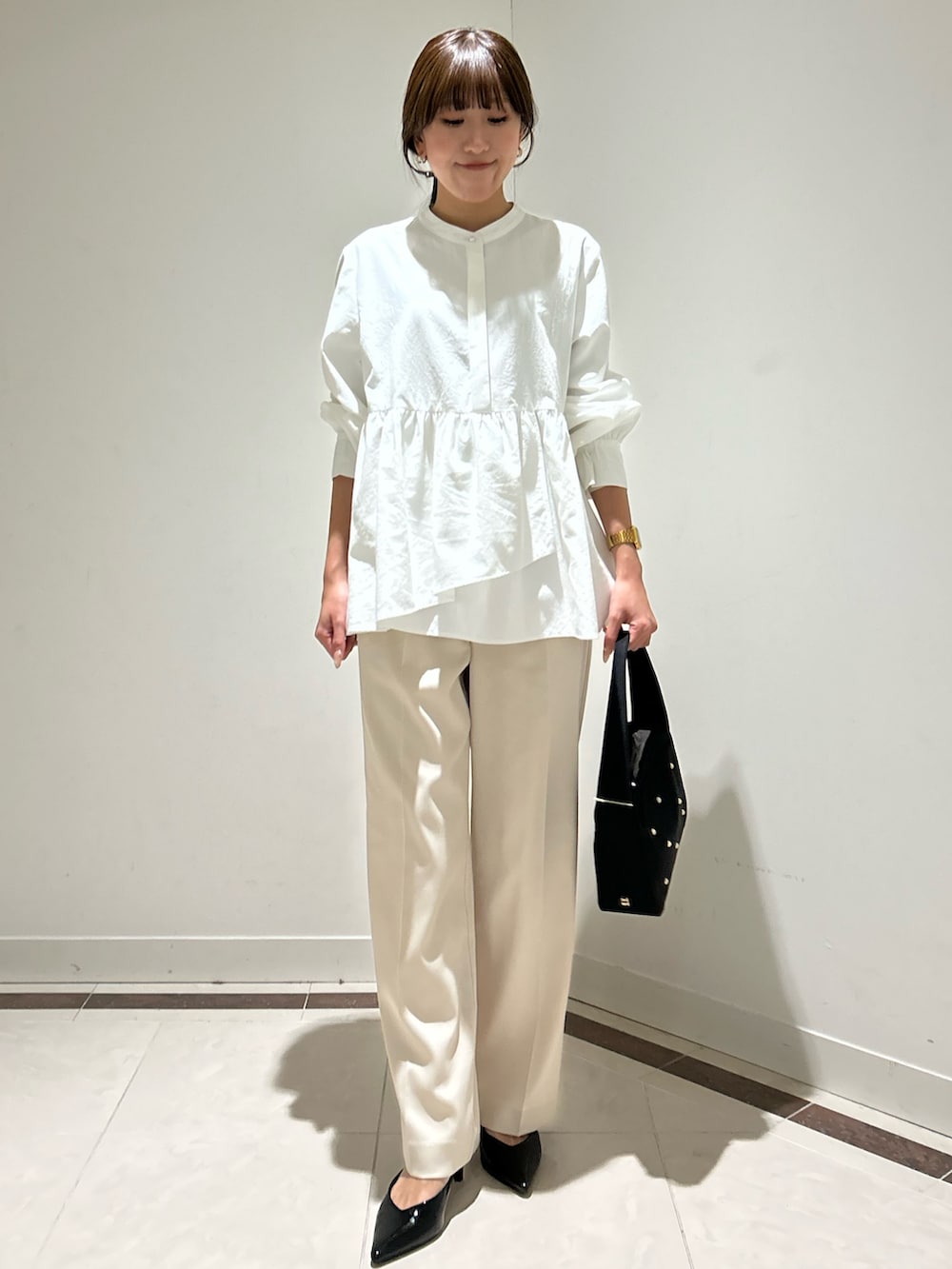 ホワイト系のシャツ/ブラウス、ホワイト系のその他パンツ、ブラック系のハンドバッグを着用したレディースの冬コーディネートの2枚目の写真