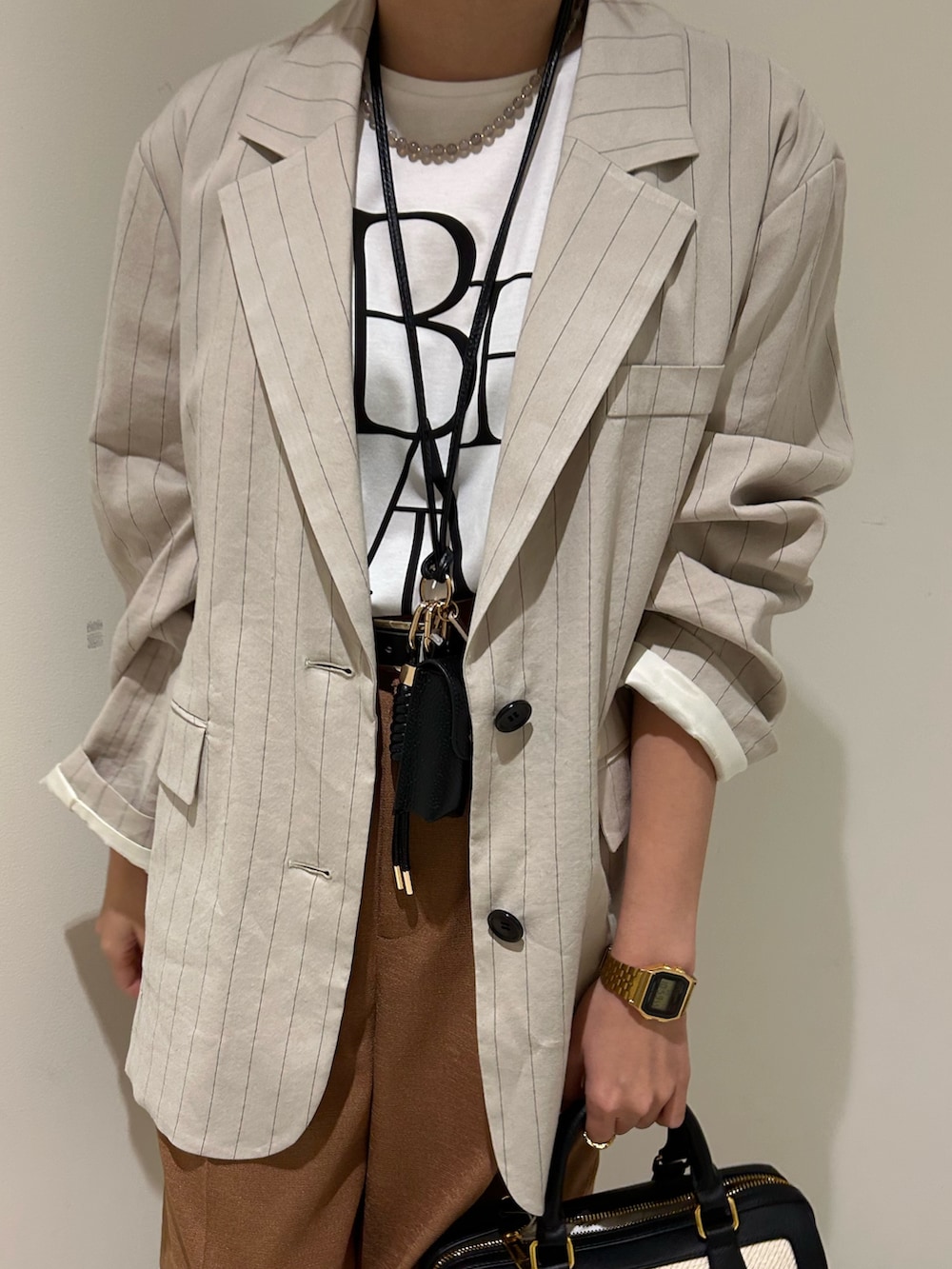 ブラック系のボストンバッグ、イエロー系のその他パンツ、ホワイト系のTシャツ/カットソーを着用したレディースの春コーディネートの4枚目の写真