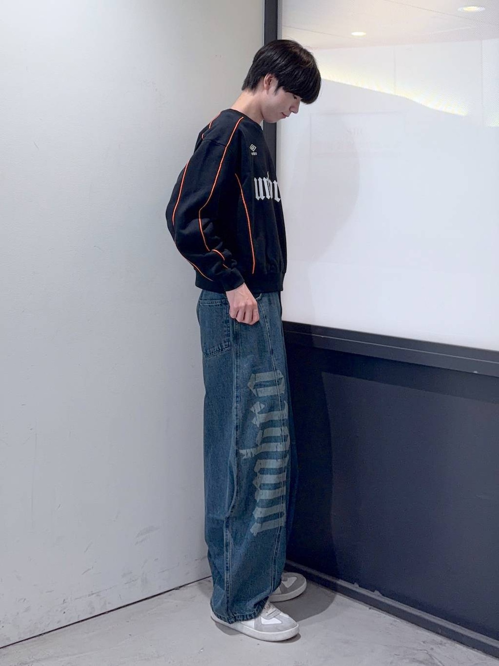 ブルー系のデニムパンツ、ブラック系のスウェットを着用したメンズの秋コーディネートの2枚目の写真