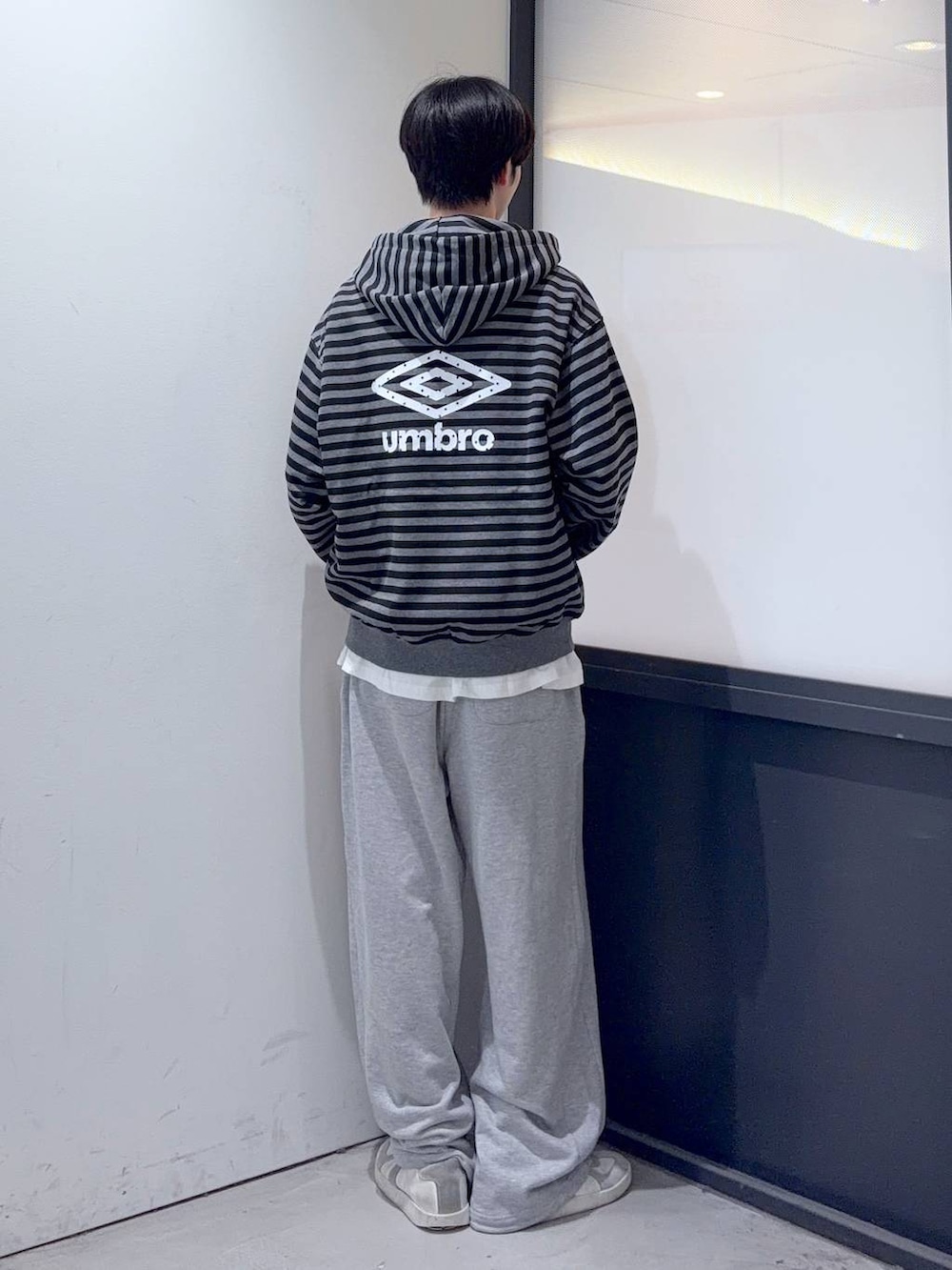 グレー系のスウェットパンツ、ブラック系のパーカーを着用したメンズの秋コーディネートの3枚目の写真