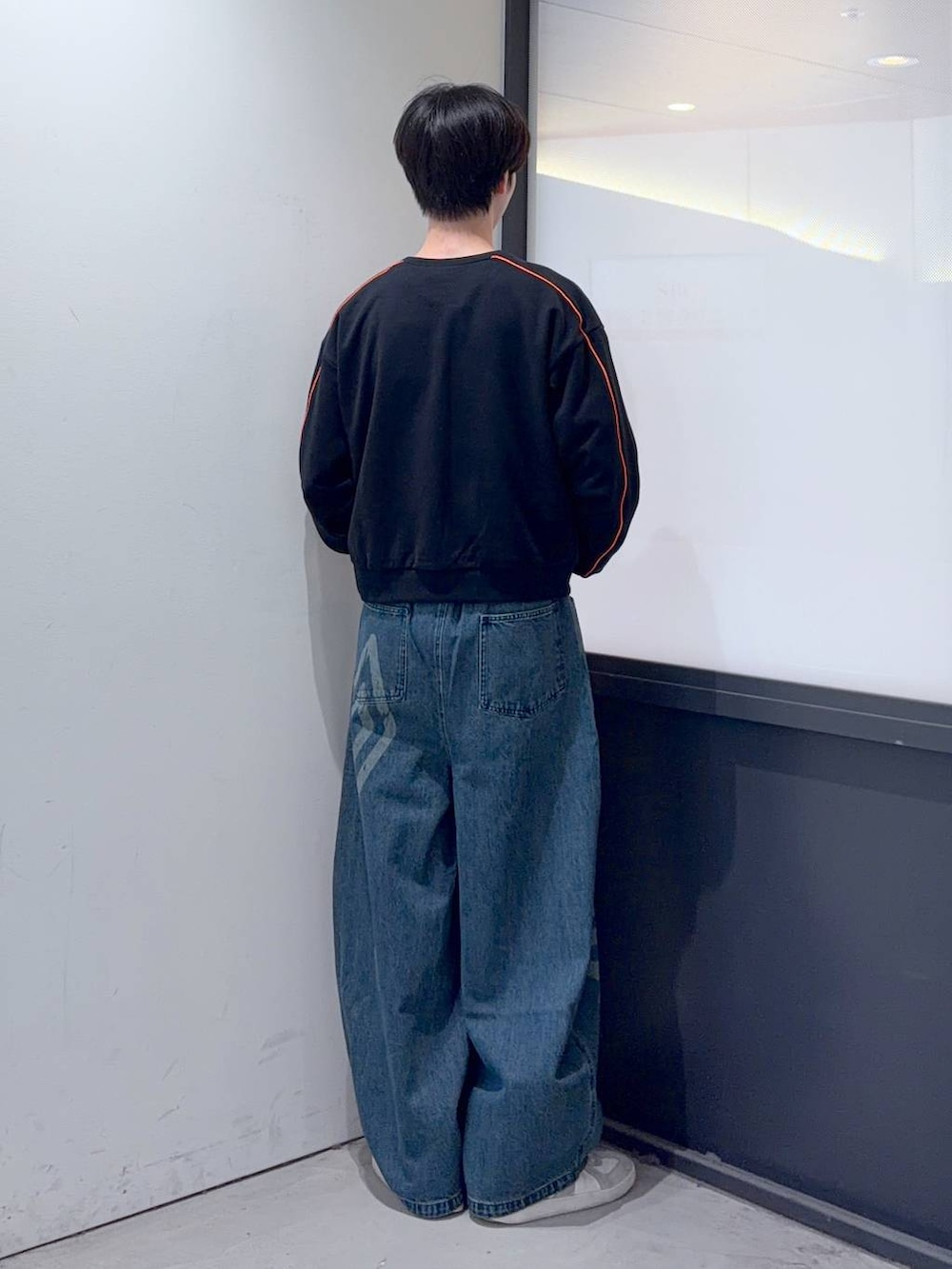 ブルー系のデニムパンツ、ブラック系のスウェットを着用したメンズの秋コーディネートの3枚目の写真