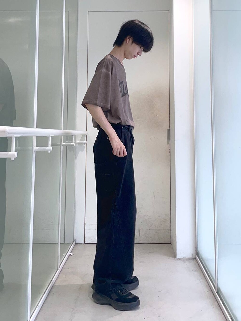 ブラック系のデニムパンツ、ブラウン系のTシャツ/カットソー、ブラック系のベルトを着用したメンズの夏コーディネートの2枚目の写真
