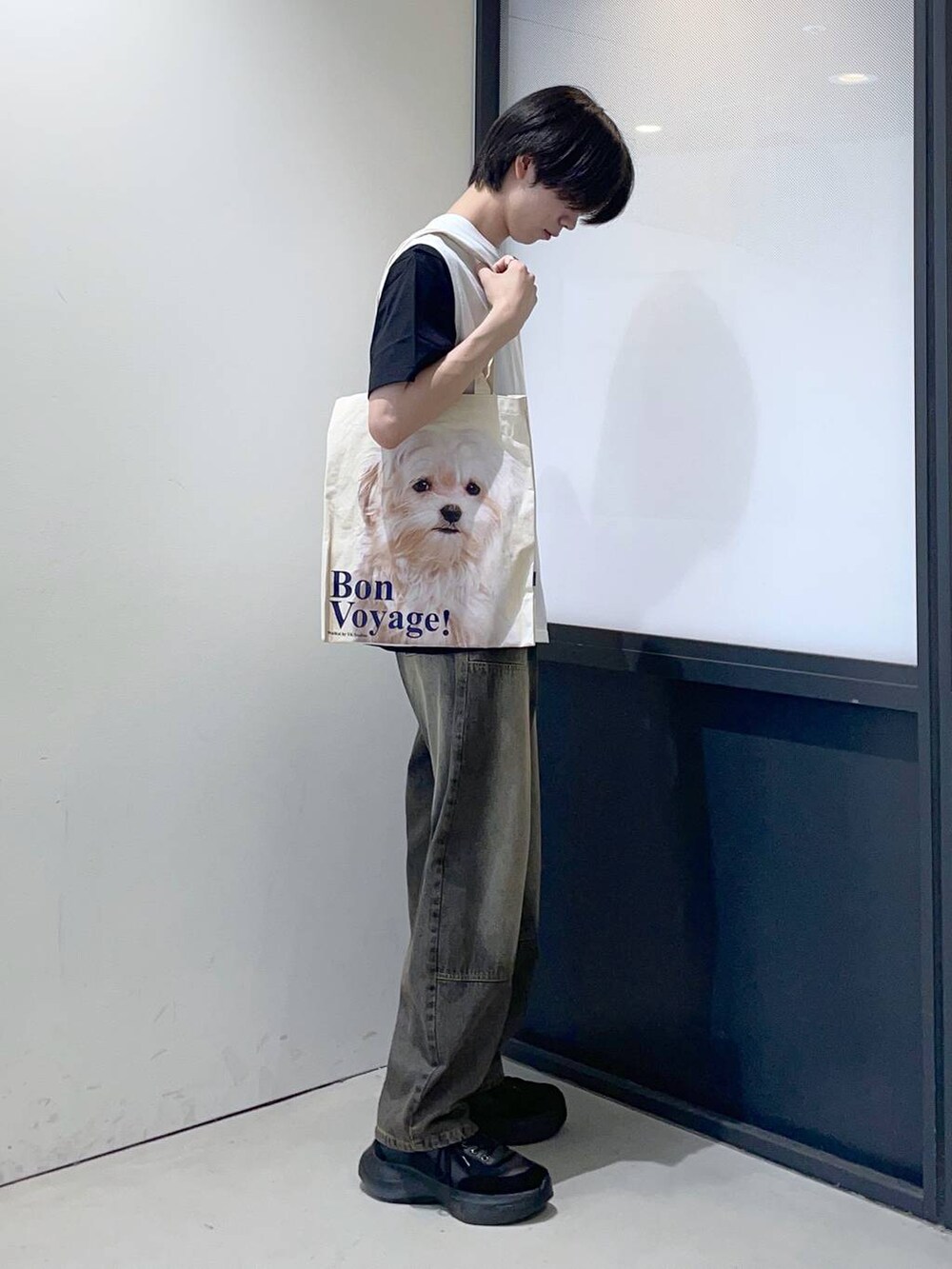 ブルー系のデニムパンツ、ベージュ系のトートバッグを着用したメンズの夏コーディネートの2枚目の写真