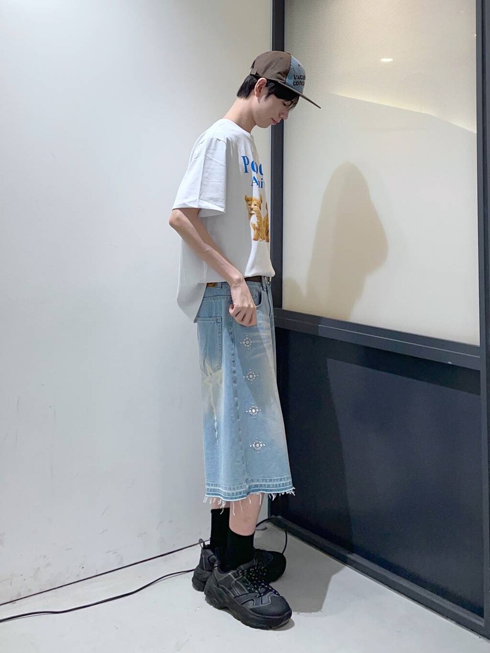 ブルー系のデニムパンツ、ホワイト系のTシャツ/カットソー、ブラウン系のベルトを着用したメンズの春コーディネートの2枚目の写真