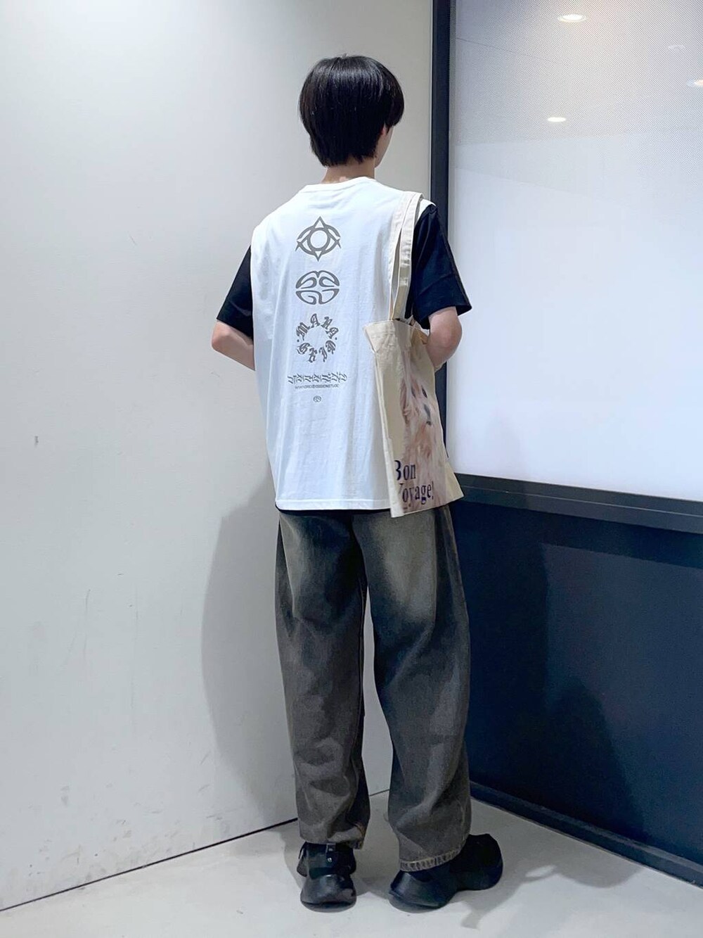 ブルー系のデニムパンツ、ベージュ系のトートバッグを着用したメンズの夏コーディネートの3枚目の写真