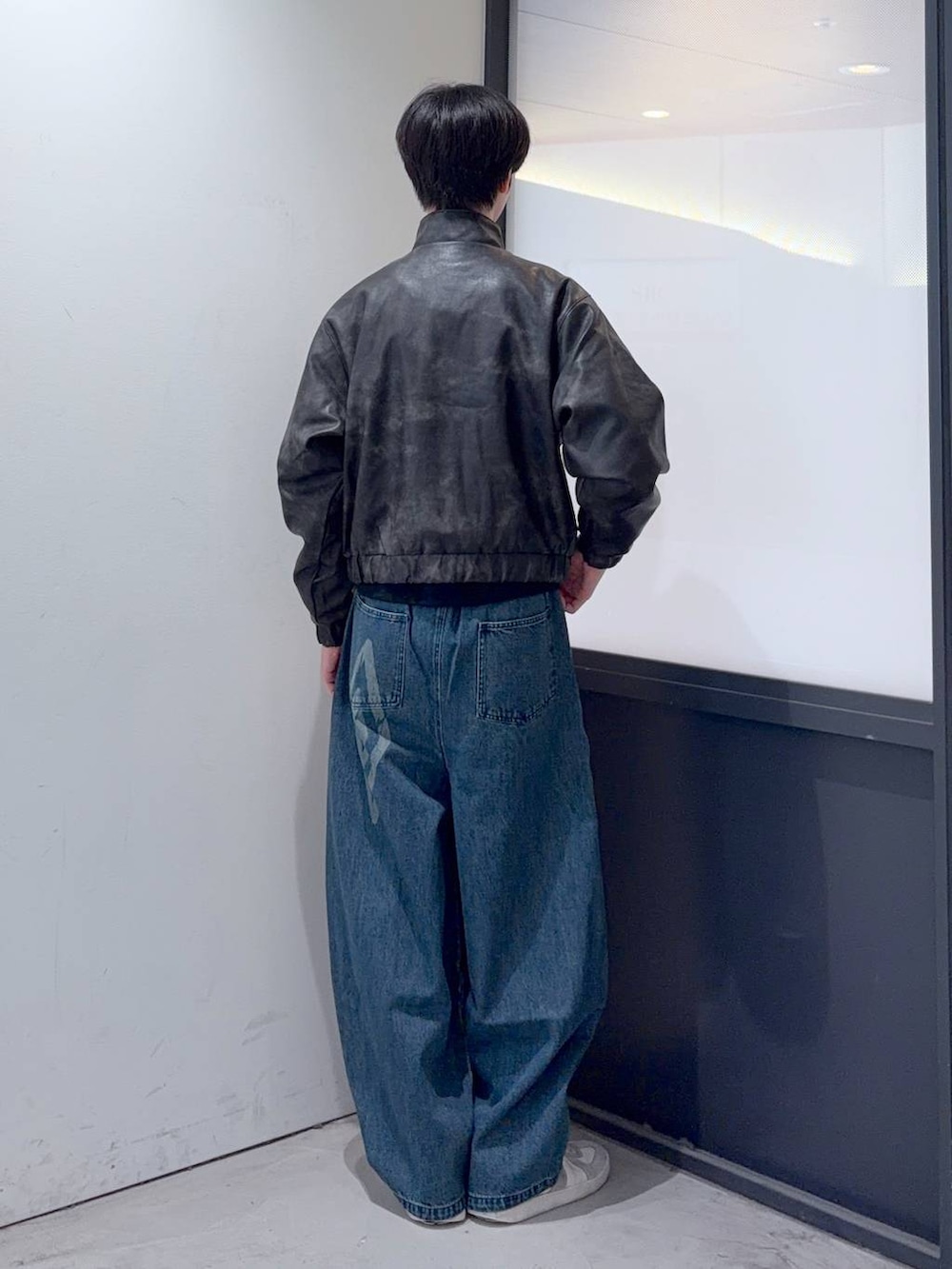 ブルー系のデニムパンツ、ブラック系のブルゾンを着用したメンズの秋コーディネートの3枚目の写真