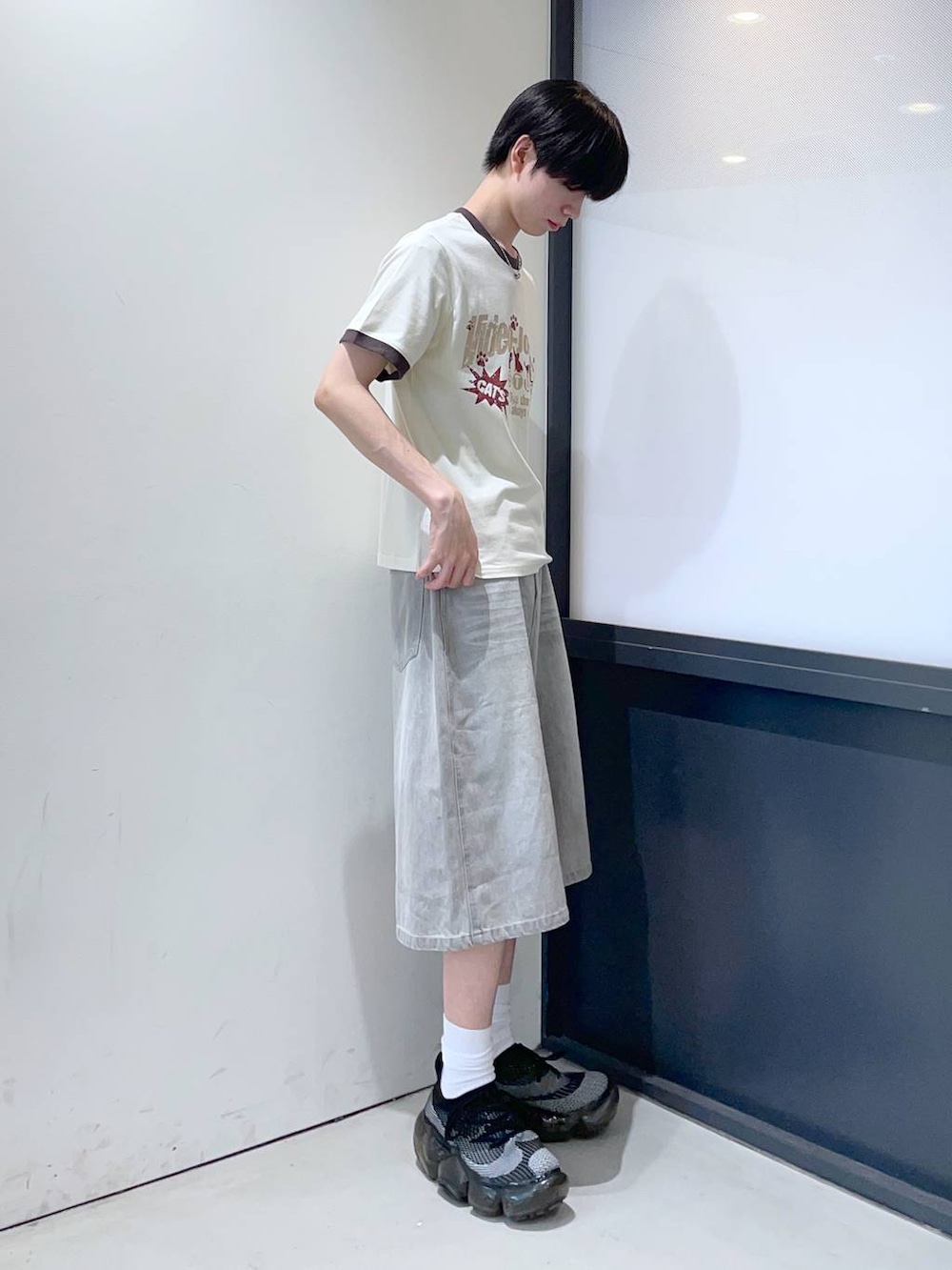 グレー系のデニムパンツ、ベージュ系のTシャツ/カットソーを着用したメンズの夏コーディネートの2枚目の写真